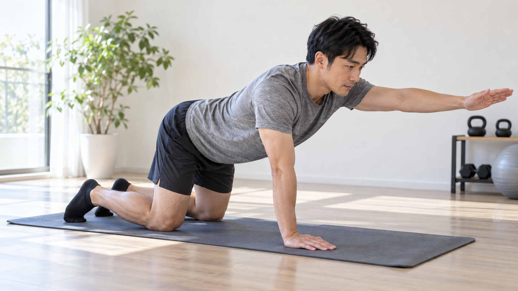 両膝を床につけた四つ這いから片腕だけを前へ伸ばす男性のイメージ