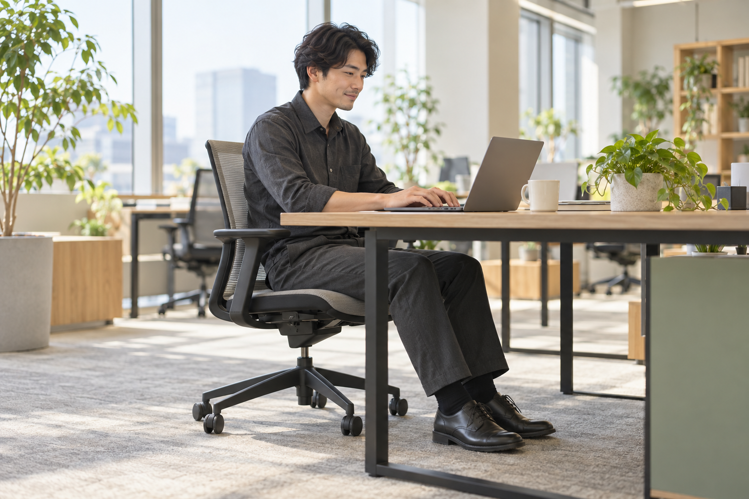 足裏を床につけてデスクで仕事をする男性のイメージ